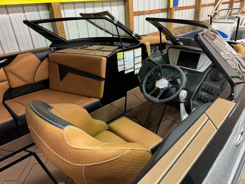 Slide: The Image of 2024 Supreme S240 boat interior with tan leather seats and modern dashboard. - 19