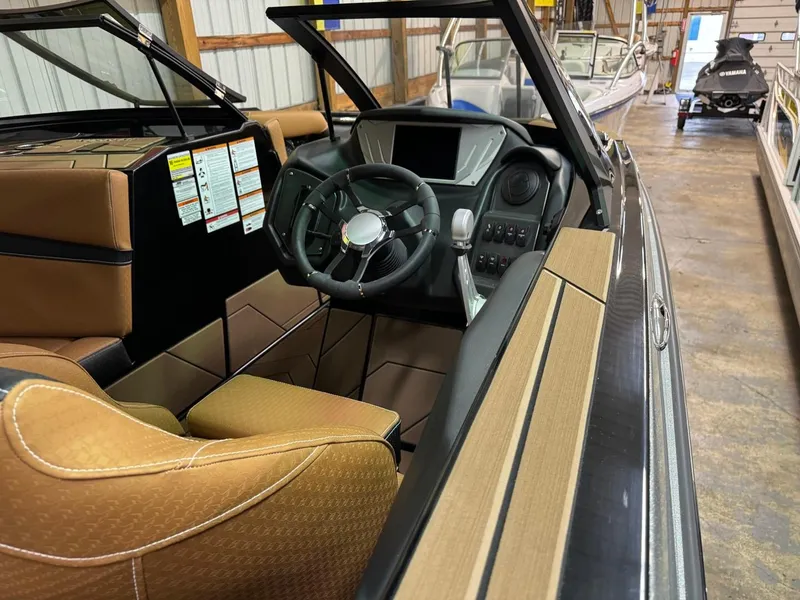 Slide: The Image of 2024 Supreme S240 boat interior with modern dashboard and tan seating. - 26