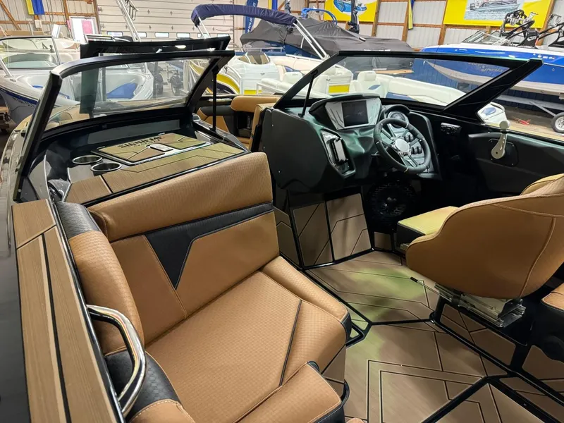 Slide: The Image of 2024 Supreme S240 boat interior with tan and black seating, modern dashboard, and steering wheel. - 31