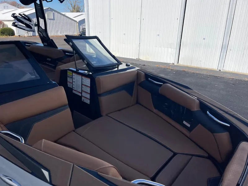 Slide: The Image of 2024 Supreme S240 boat interior with brown seating and modern dashboard. - 8