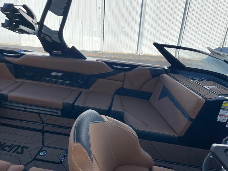 Slide: The Image of 2024 Supreme S240 boat interior with brown leather seating and modern dashboard design. - 9