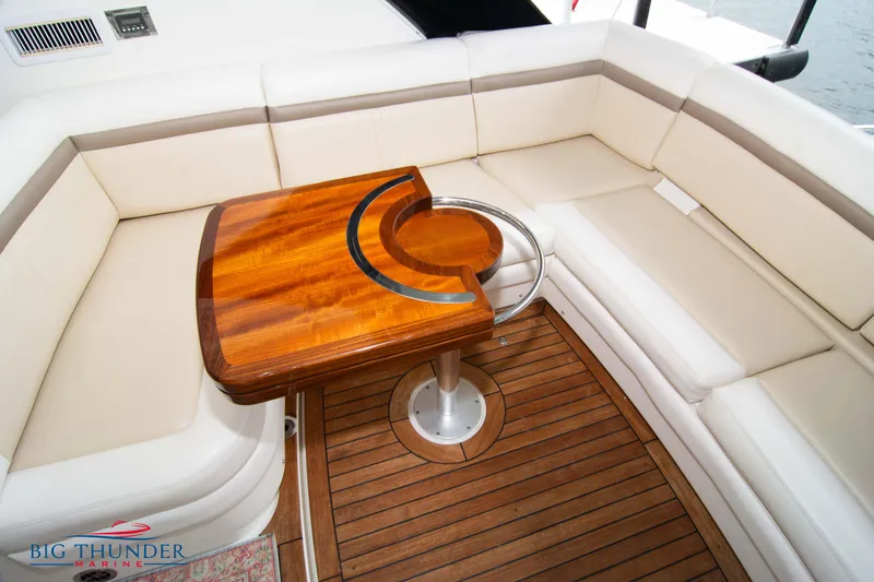 Slide: The Image of Luxurious seating area on 2012 Sea Ray 410 Sundancer with wooden table and cushioned seats. - 19