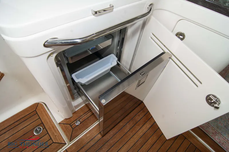 Slide: The Image of 2012 Sea Ray 410 Sundancer boat interior with open storage compartment and wooden flooring. - 24