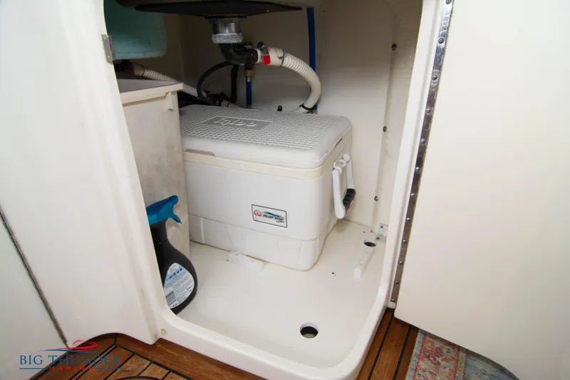 Slide: The Image of Storage compartment on 2012 Sea Ray 410 Sundancer boat with cooler and cleaning supplies. - 25