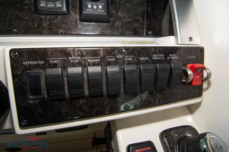 Slide: The Image of Control panel of a 2012 Sea Ray 410 Sundancer boat with various switches. - 34