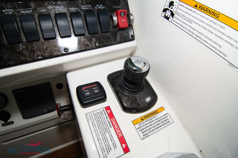 Slide: The Image of Control panel of 2012 Sea Ray 410 Sundancer with warning labels and switches. - 38