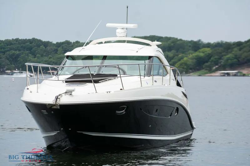 Slide: The Image of 2012 Sea Ray 410 Sundancer yacht on a serene lake. - 4