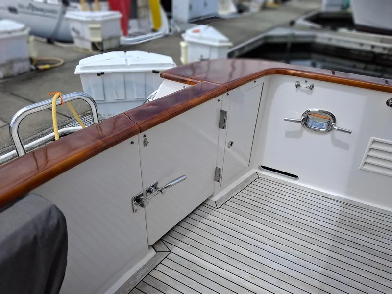 Slide: The Image of 2004 Ocean Alexander 64 Pilothouse yacht deck with wooden rail and storage compartments. - 35