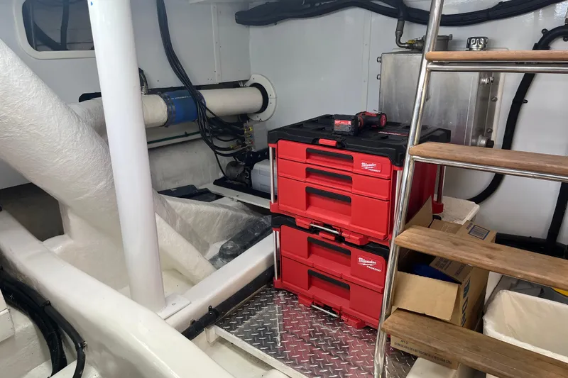 Slide: The Image of Engine room of 2004 Ocean Alexander 64 Pilothouse with toolboxes and ladder. - 43