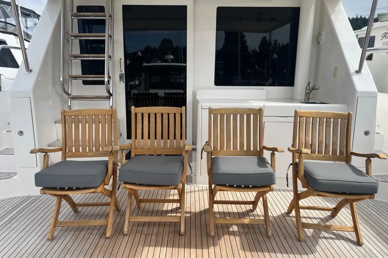 Slide: The Image of Four wooden chairs with cushions on a 2004 Ocean Alexander 64 Pilothouse yacht deck. - 45
