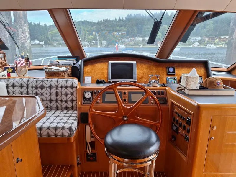 Slide: The Image of Pilothouse interior of 2004 Ocean Alexander 64, featuring wooden helm and modern navigation equipment. - 9