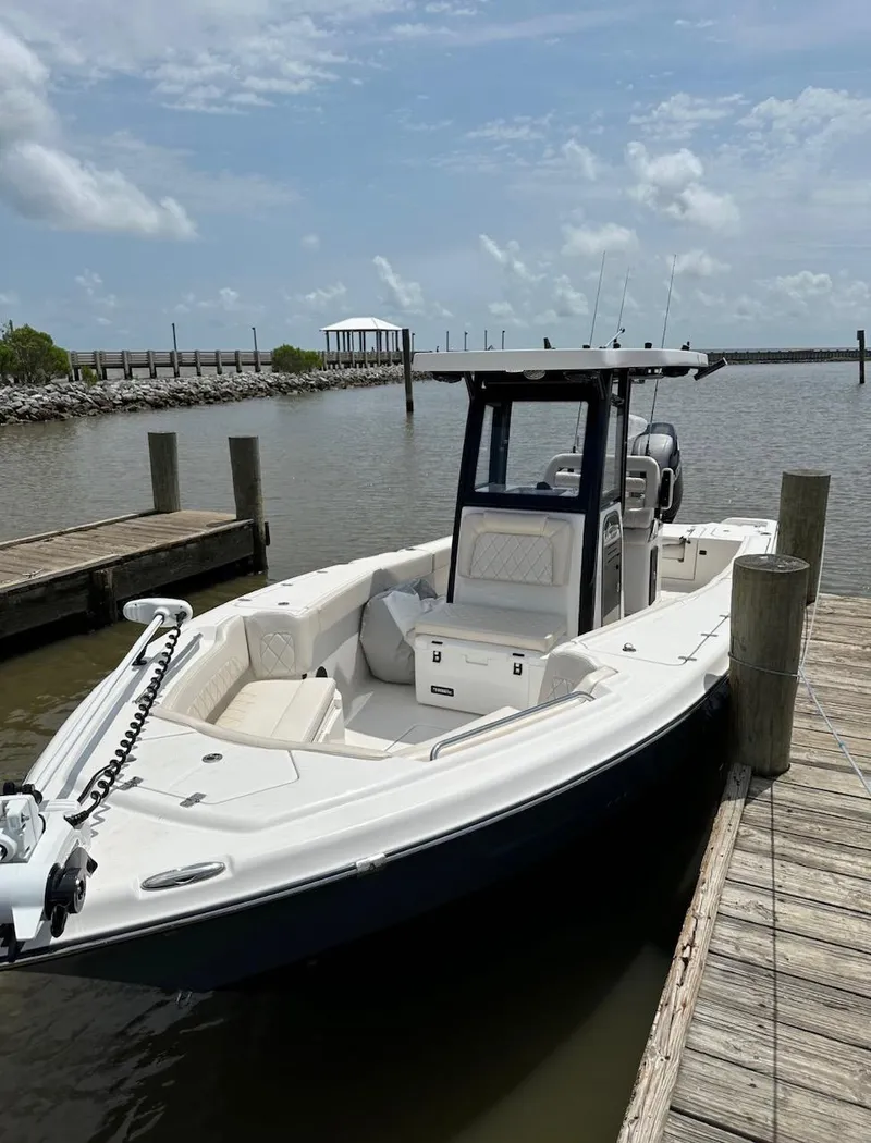 Slide: The Image of 2024 Blue Wave 2600 Makaira boat docked by a wooden pier under a cloudy sky. - 3