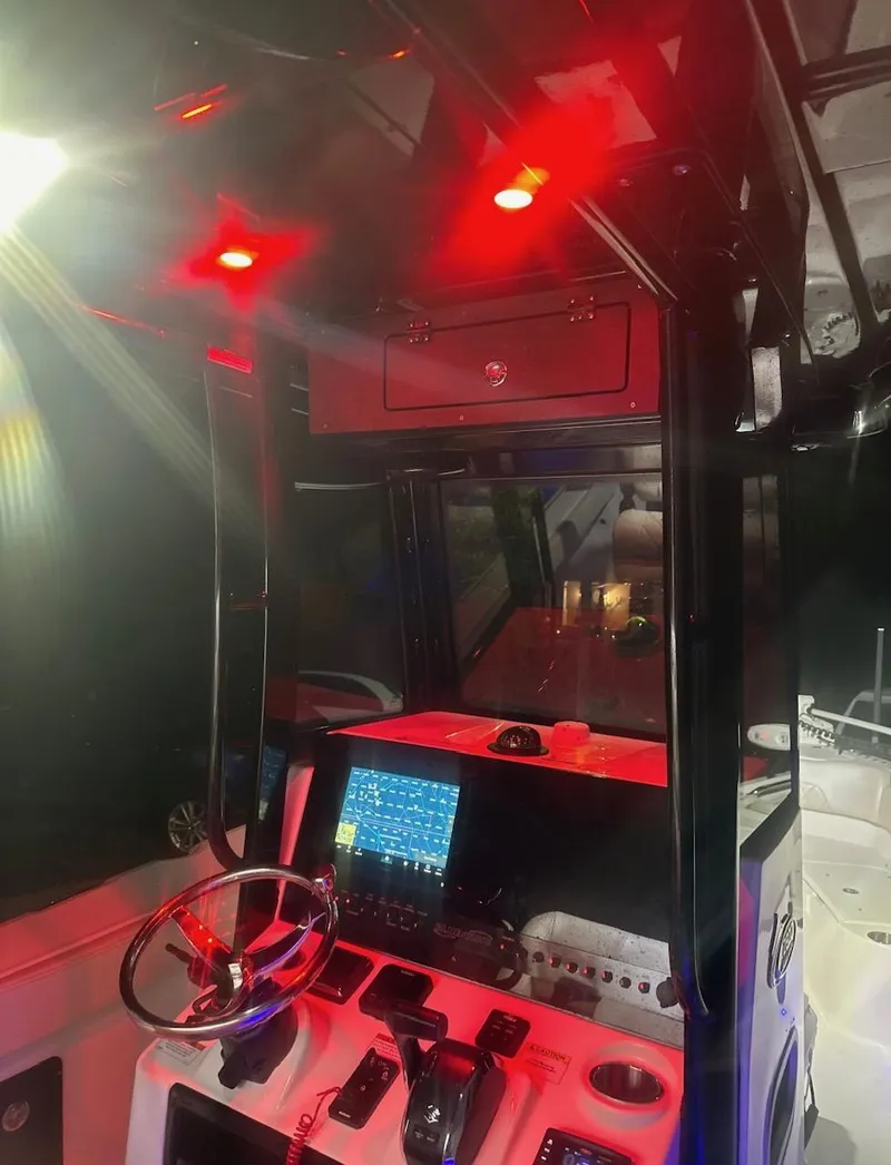 Slide: The Image of 2024 Blue Wave 2600 Makaira boat interior with red lighting and navigation equipment. - 6