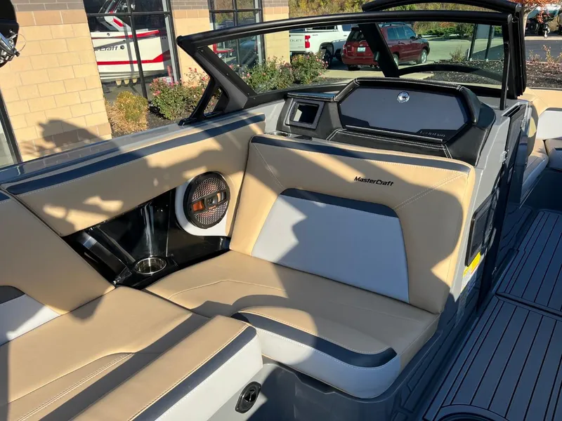 Slide: The Image of 2024 MasterCraft XStar S boat interior with beige seating and modern dashboard. - 13