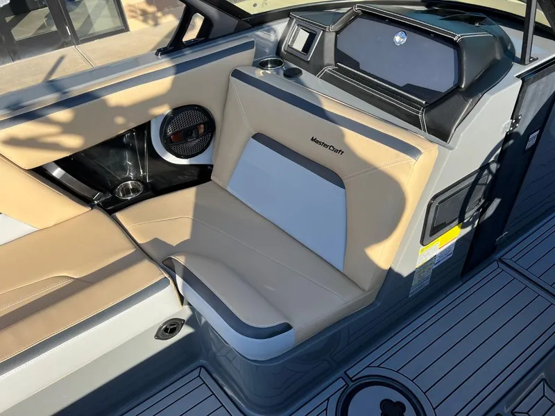 Slide: The Image of 2024 MasterCraft XStar S boat interior with beige seating and modern dashboard. - 14