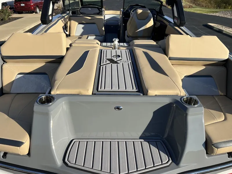Slide: The Image of 2024 MasterCraft XStar S boat interior with beige seating and gray accents. - 18