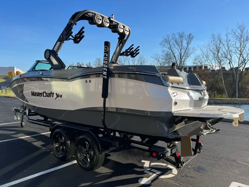 Slide: The Image of 2024 MasterCraft XStar S boat on trailer in parking lot, side view. - 23
