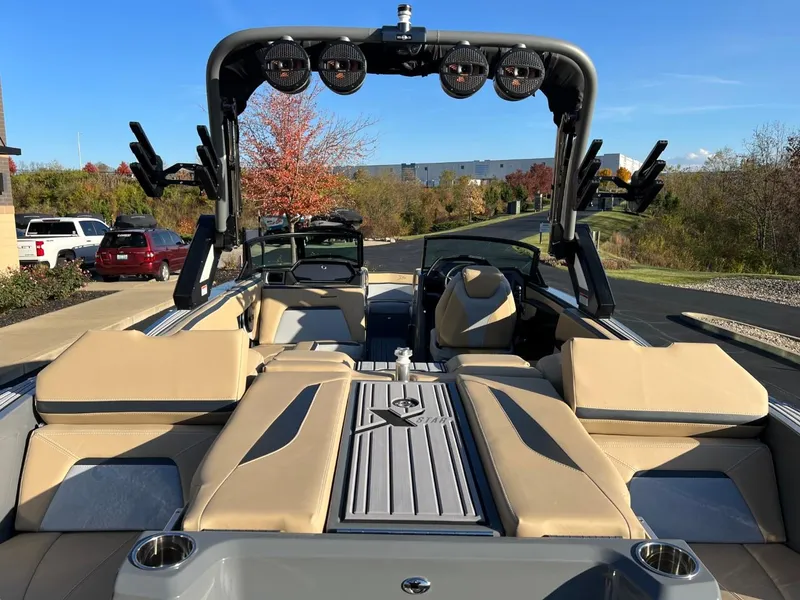 Slide: The Image of 2024 MasterCraft XStar S boat interior with beige seating and wakeboard tower. - 25