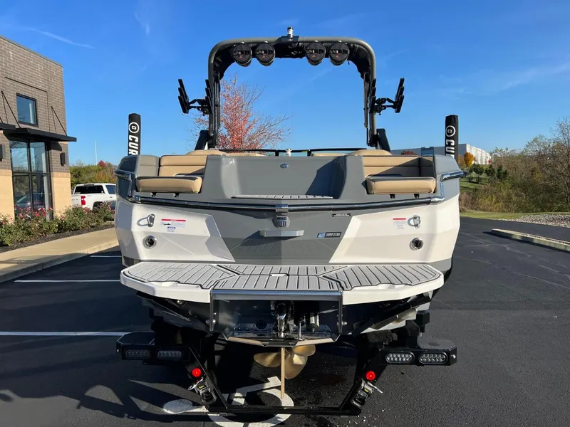 Slide: The Image of 2024 MasterCraft XStar S boat, rear view, parked outdoors on a sunny day. - 5