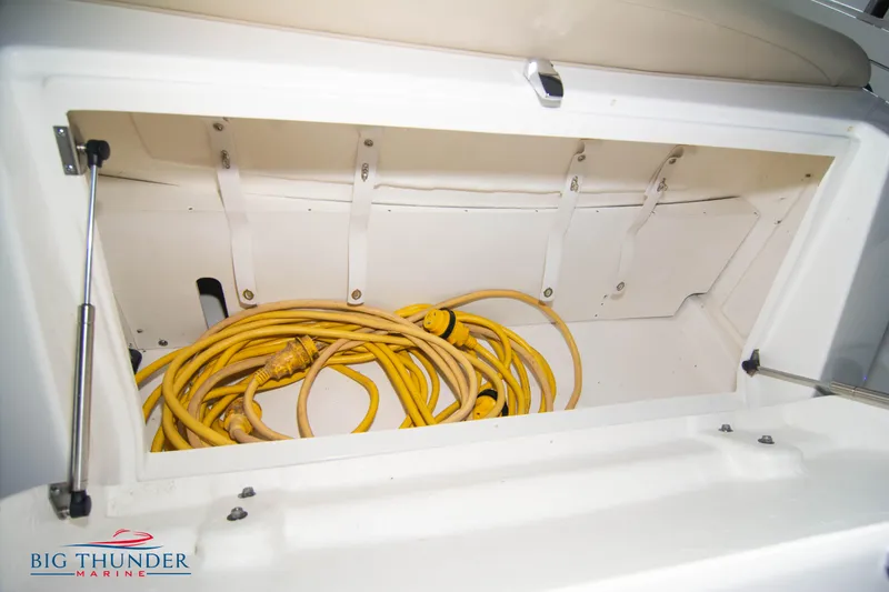 Slide: The Image of Storage compartment with yellow cables on a 2016 Sea Ray 370 Sundancer boat. - 12