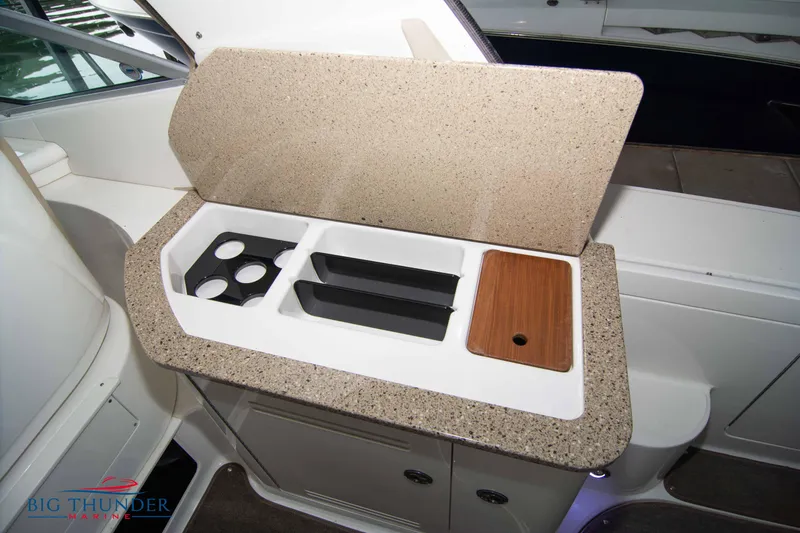 Slide: The Image of 2016 Sea Ray 370 Sundancer boat kitchenette with countertop and storage compartments. - 18