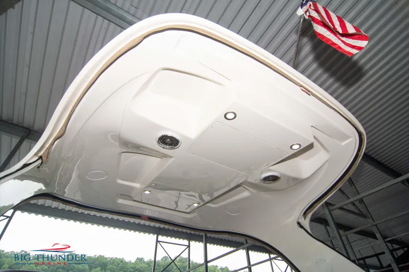 Slide: The Image of 2016 Sea Ray 370 Sundancer boat under a metal roof with American flag. - 20