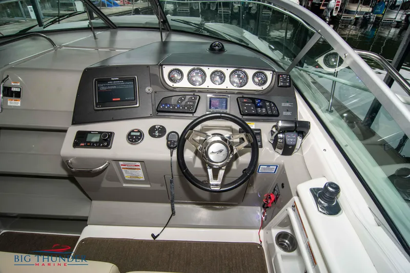 Slide: The Image of 2016 Sea Ray 370 Sundancer helm with modern controls and navigation instruments. - 21