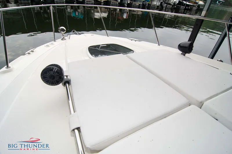 Slide: The Image of 2016 Sea Ray 370 Sundancer boat deck with sun pads and railing at marina. - 43