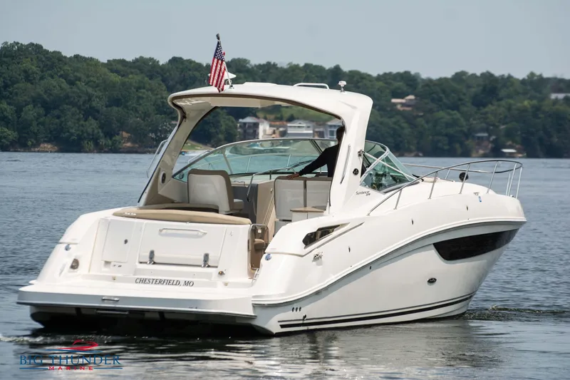 Slide: The Image of 2016 Sea Ray 370 Sundancer boat on a lake with lush green shoreline. - 6
