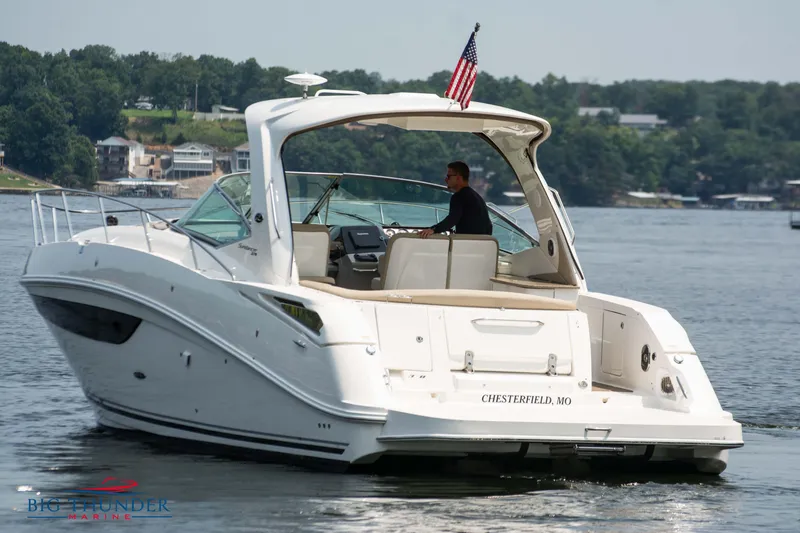 Slide: The Image of 2016 Sea Ray 370 Sundancer cruising on a lake with American flag. - 8