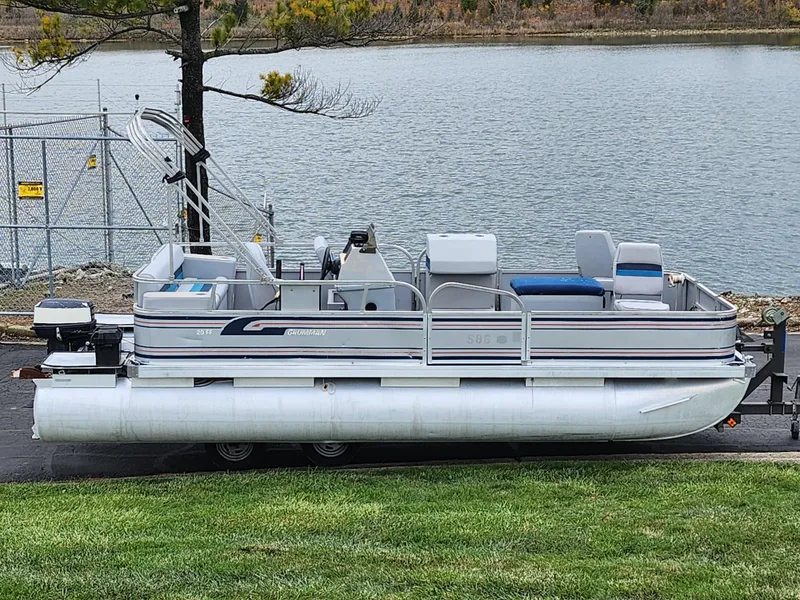 Slide: The Image of 1991 Grumman Fish N Fun 20' pontoon boat by a lakeside. - 0