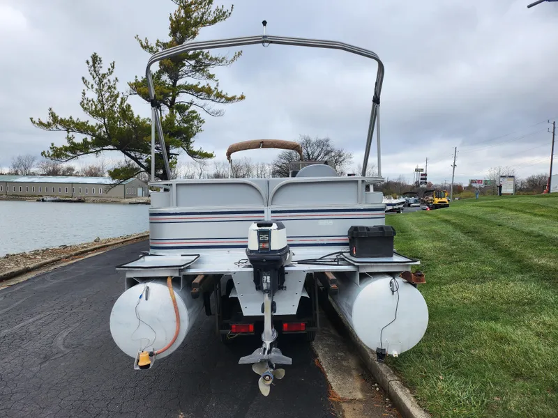 Slide: The Image of 1991 Grumman Fish N Fun 20' pontoon boat parked by a lakeside. - 2