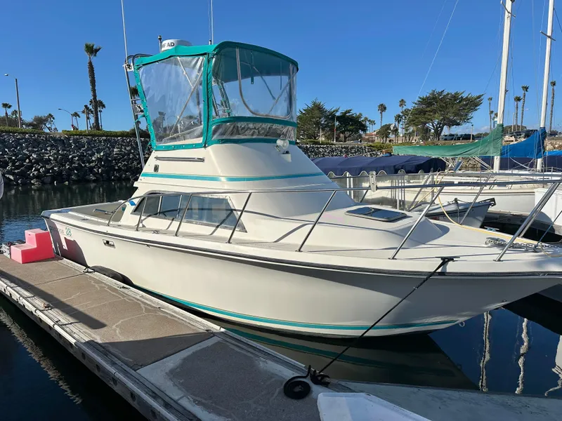 Slide: The Image of 1994 Precision 28 Convertible boat docked in a marina under clear blue skies. - 0
