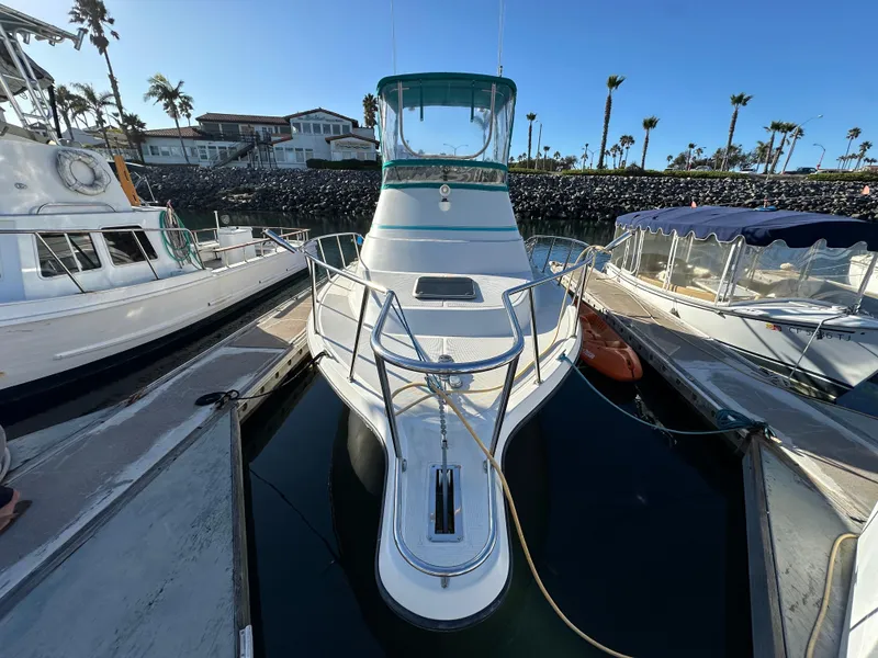 Slide: The Image of 1994 Precision 28 Convertible boat docked at marina, surrounded by other vessels. - 1