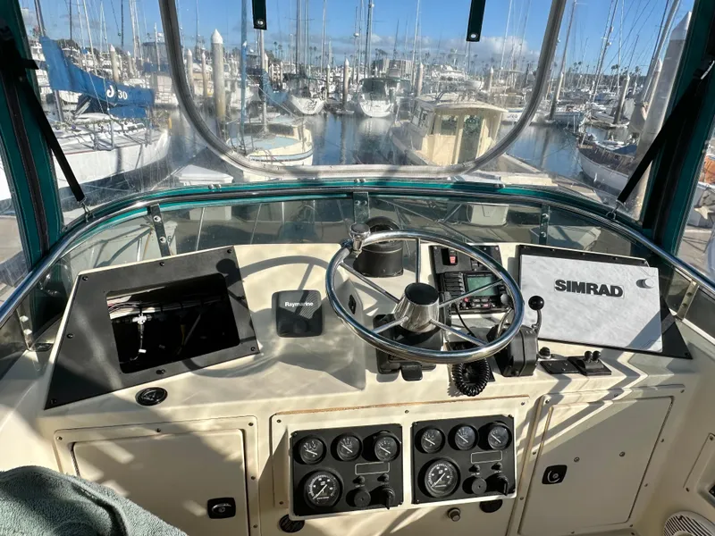 Slide: The Image of 1994 Precision 28 Convertible boat helm with Simrad navigation, marina view. - 12