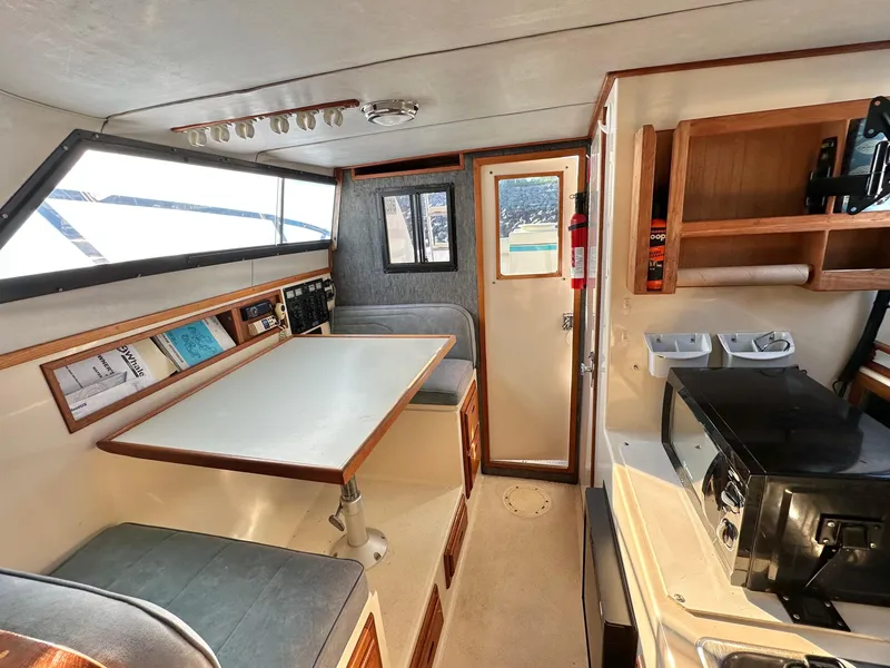 Slide: The Image of 1994 Precision 28 Convertible boat interior with dining area and kitchenette. - 20
