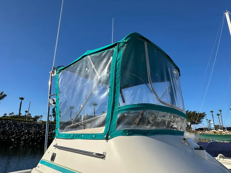 Slide: The Image of 1994 Precision 28 Convertible boat with green canopy in sunny marina. - 8