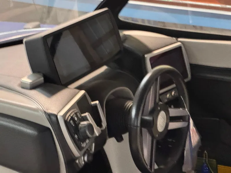 Slide: The Image of 2015 Malibu Wakesetter 22 MXZ dashboard with modern controls and steering wheel. - 10