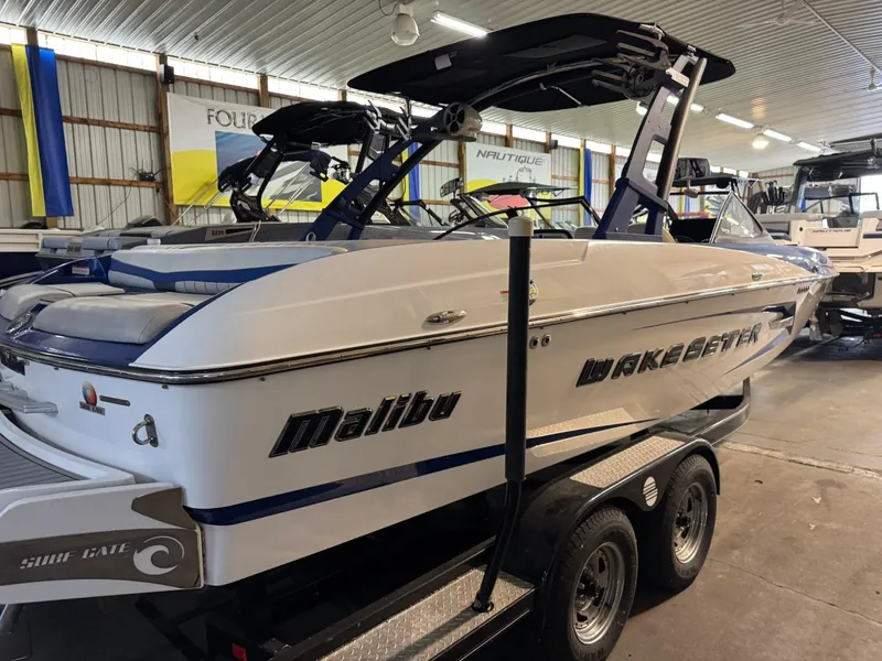 Slide: The Image of 2015 Malibu Wakesetter 22 MXZ boat in a showroom, on a trailer. - 18