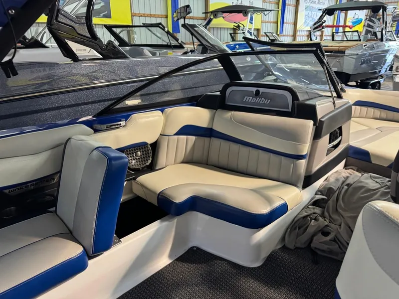 Slide: The Image of 2015 Malibu Wakesetter 22 MXZ interior with blue and white seating in showroom. - 24