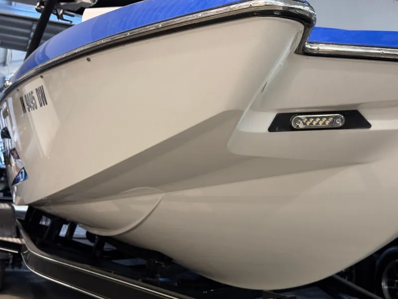 Slide: The Image of 2015 Malibu Wakesetter 22 MXZ boat hull with blue trim, close-up view. - 30