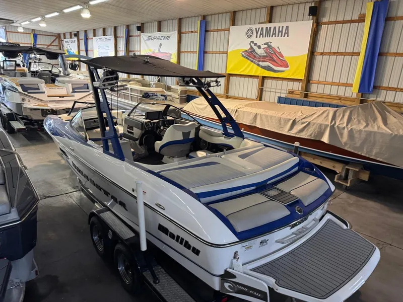 Slide: The Image of 2015 Malibu Wakesetter 22 MXZ boat in showroom, featuring sleek design and spacious interior. - 32