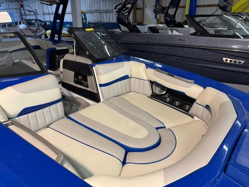 Slide: The Image of 2015 Malibu Wakesetter 22 MXZ interior with blue and white seating in a showroom. - 4