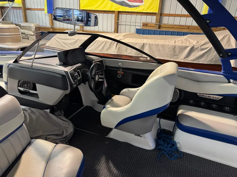 Slide: The Image of 2015 Malibu Wakesetter 22 MXZ interior with white and blue seating, steering wheel, and dashboard. - 9
