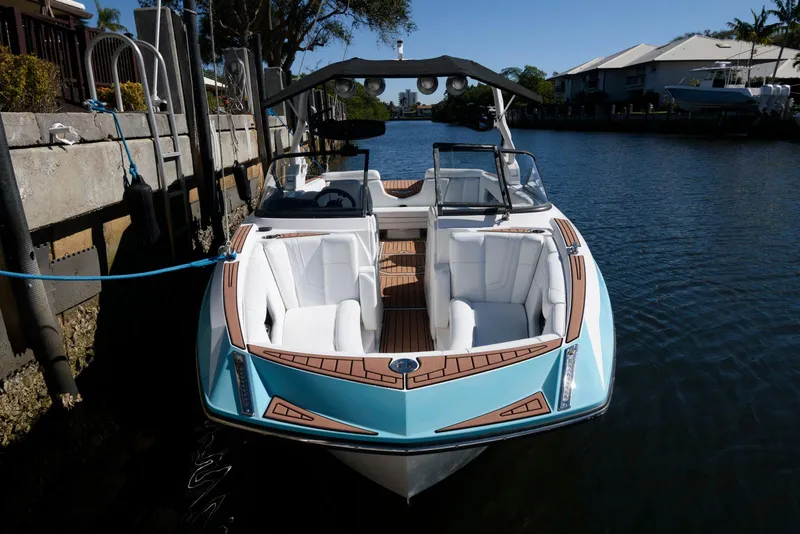 Slide: The Image of 2017 Nautique Super Air Nautique G25 boat docked in a sunny canal. - 1