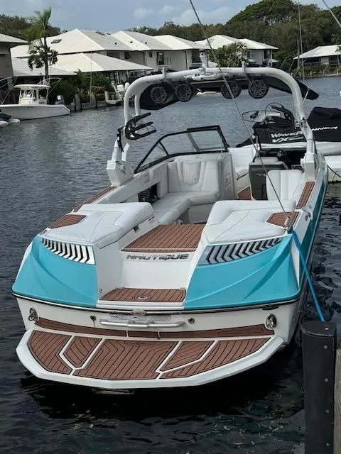Slide: The Image of 2017 Nautique Super Air Nautique G25 boat on trailer by waterfront. - 2
