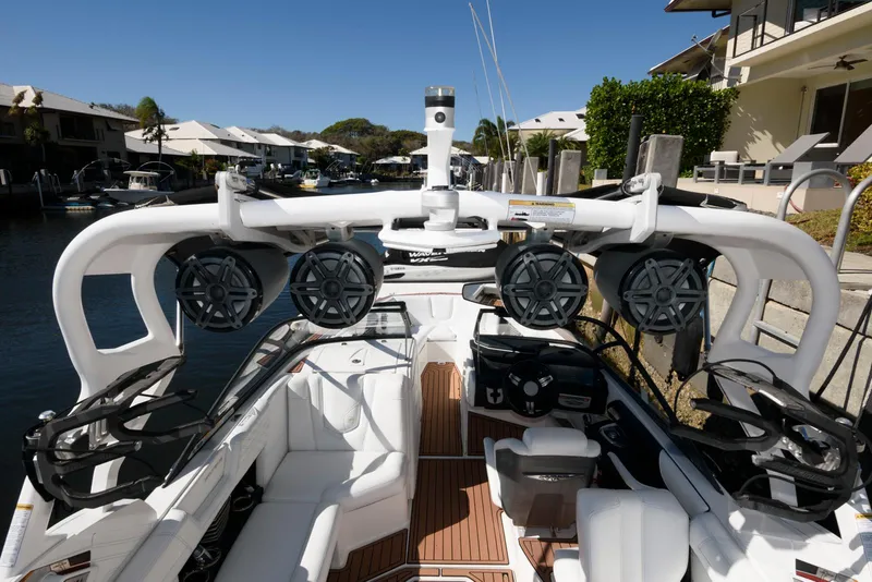 Slide: The Image of 2017 Nautique Super Air Nautique G25 boat docked on a calm waterfront. - 4