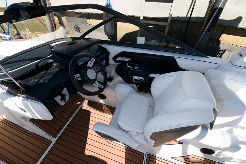 Slide: The Image of 2017 Nautique Super Air Nautique G25 boat interior with white seating and wood flooring. - 7