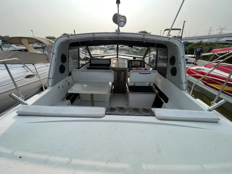 Slide: The Image of 1987 Carver Riviera 2807 boat interior with seating and table, docked at marina. - 6