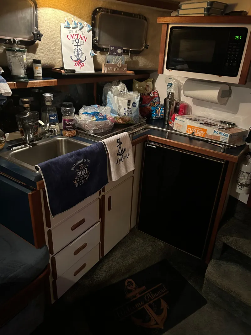 Slide: The Image of Compact kitchen in 1987 Carver Riviera 2807 boat with sink, microwave, and storage. - 10